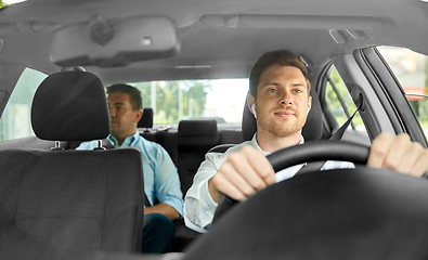 Image showing male driver with wireless earphones driving car