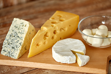 Image showing different kinds of cheese on wooden cutting board