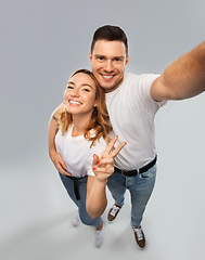 Image showing happy couple in white t-shirts taking selfie