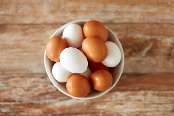 Image showing close up of eggs in ceramic bowl on wooden table