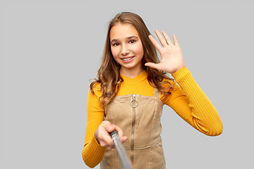 Image showing happy teenage girl taking selfie and waving hand