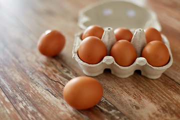 Image showing close up of eggs in cardboard box on wooden table