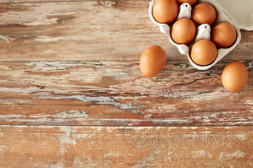 Image showing close up of eggs in cardboard box on wooden table