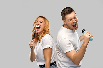 Image showing happy couple singing to hairbrush and lotion