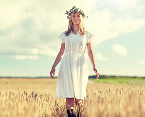 Image showing happy young woman in flower wreath on cereal field