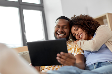 Image showing happy couple with tablet pc computer at new home