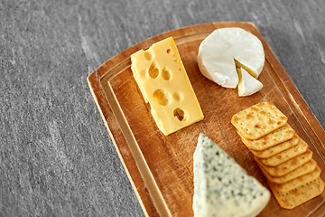 Image showing different cheeses and crackers on wooden board