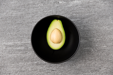 Image showing close up of ripe avocado with bone in ceramic bowl