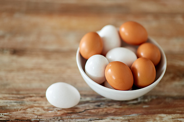 Image showing close up of eggs in ceramic bowl on wooden table