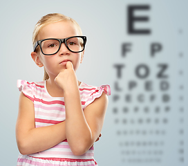 Image showing little girl in glasses over eye test chart