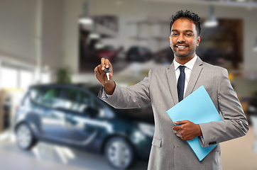 Image showing happy indian car dealer with car key at showroom