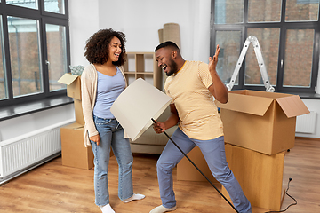 Image showing happy couple packing boxes and moving to new home