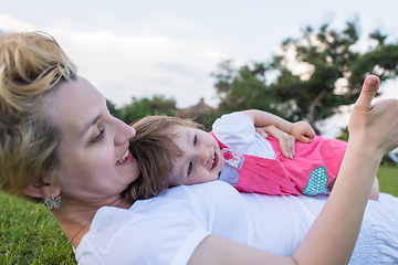 Image showing mother and little daughter playing at backyard