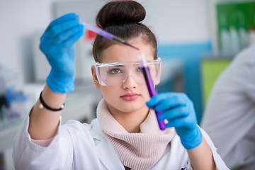 Image showing female student with protective glasses making chemistry experime