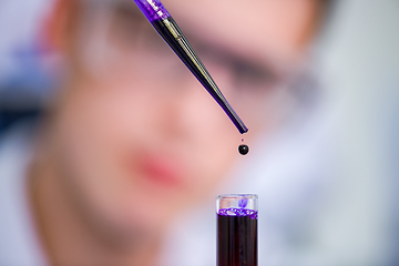 Image showing student with protective glasses making chemistry experiment