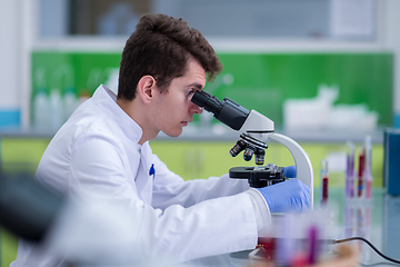 Image showing student scientist looking through a microscope