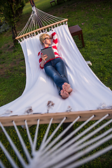 Image showing woman using a tablet computer while relaxing on hammock