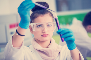 Image showing female student with protective glasses making chemistry experime