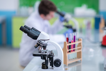 Image showing student scientist looking through a microscope