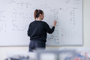 Image showing female student writing on board in classroom