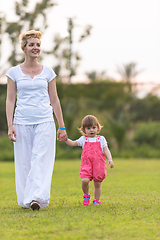 Image showing mother and little daughter playing at backyard