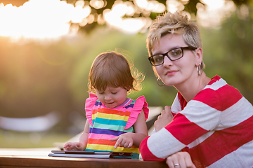 Image showing mom and her little daughter using tablet computer