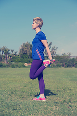 Image showing female runner warming up and stretching