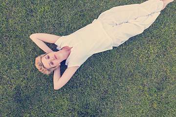 Image showing top view of young woman relaxing on the grass