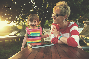 Image showing mom and her little daughter using tablet computer