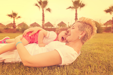 Image showing mother and little daughter playing at backyard