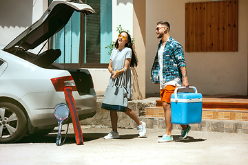 Image showing Young couple preparing for vacation trip on the car in sunny day