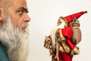 Image showing bearded man looking to a Santa Claus puppet