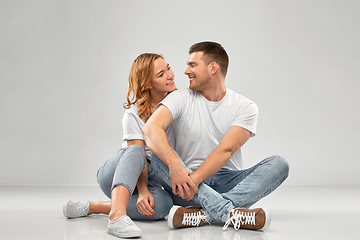 Image showing happy couple in white t-shirts sitting on floor