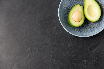 Image showing close up of ripe avocado with bone in ceramic bowl