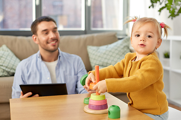 Image showing father with tablet pc and baby daughter at home