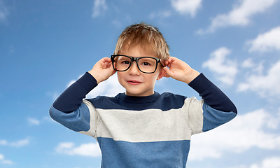 Image showing portrait of smiling little boy in glasses over sky