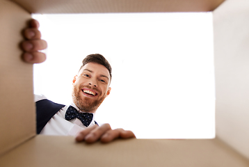 Image showing happy young man looking into open gift box