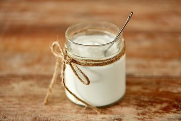 Image showing yogurt or sour cream in glass jar on wooden table