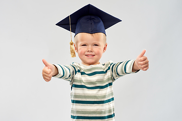 Image showing happy little boy in mortar board showing thumbs up