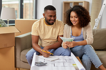 Image showing couple with blueprint counting money at home