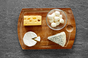 Image showing different kinds of cheese on wooden cutting board