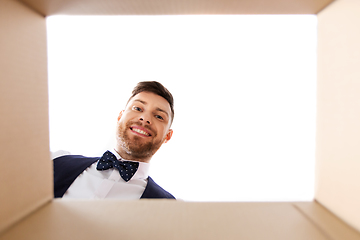 Image showing happy young man looking into open gift box