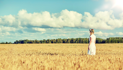 Image showing happy young woman in flower wreath on cereal field