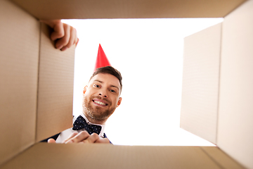 Image showing happy young man looking into open birthday gift