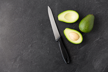 Image showing avocados and knife on slate stone background