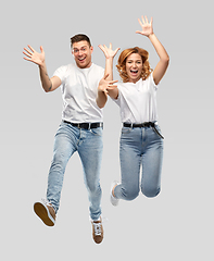 Image showing happy couple in white t-shirts jumping