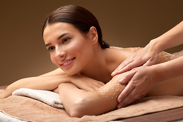 Image showing happy woman having exfoliating salt massage at spa