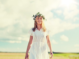 Image showing smiling young woman in wreath of flowers outdoors