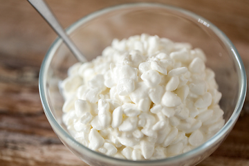 Image showing close up of cottage cheese in bowl on wooden table