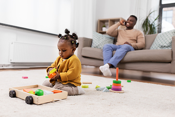 Image showing african baby girl playing with toy blocks at home